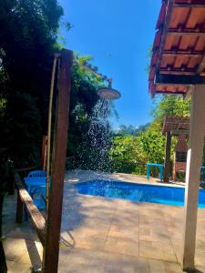 a swimming pool with a table and chairs next to it at Pousada Bella Ana in Visconde De Maua