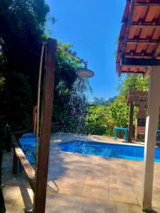 una piscina con tavolo e sedie accanto di Pousada Bella Ana a Visconde De Maua