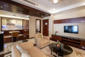 a living room with a couch and a tv and a table at The Imperial Mansion, Beijing - Marriott Executive Apartments in Beijing