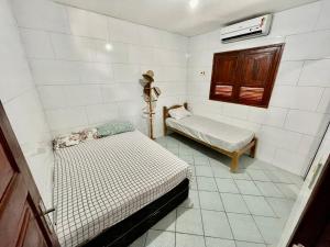 a small room with two beds and a window at Casa Ilha de Itamaracá in Vila Velha