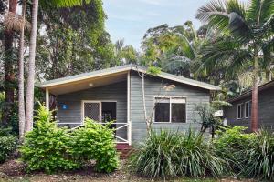 mały domek z palmami przed nim w obiekcie NRMA Darlington Beach Holiday Resort w mieście Arrawarra