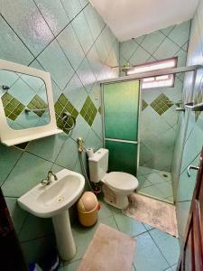 a bathroom with a sink and a toilet and a mirror at Casa Ilha de Itamaracá in Vila Velha