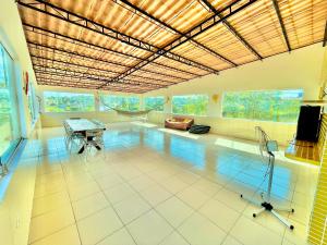a large room with a pool with a table and a couch at Casa Ilha de Itamaracá in Vila Velha