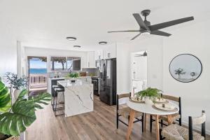 uma cozinha com uma mesa e uma ventoinha de tecto em Serenity by the Sea Ultimate Beachfront Escape em Hauula