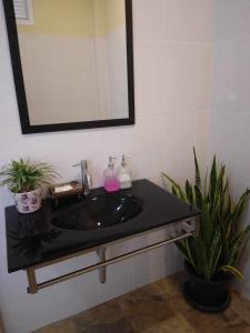 uma casa de banho com um lavatório preto e um espelho em Baan I Ta Lay Koh Yao Noi em Ko Yao Noi