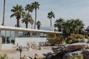 a house on the beach with palm trees at Miracle Manor Boutique Hotel & Spa in Desert Hot Springs