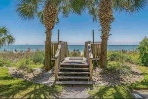 a staircase leading to the beach with palm trees at Soul Sanctuary-Direct oceanfront-Million dollars view-King bed-Free Parking-Self check-in in Myrtle Beach