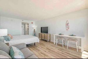 a bedroom with a bed and a desk and a television at Soul Sanctuary-Direct oceanfront-Million dollars view-King bed-Free Parking-Self check-in in Myrtle Beach