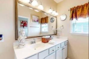 uma casa de banho com 2 lavatórios e um espelho grande em The Lucky Charm em Savannah
