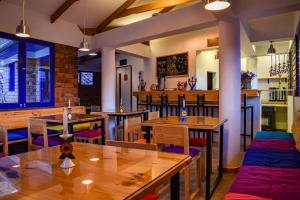 un restaurante con mesas de madera y sillas moradas en Saqray Hostel en Cusco