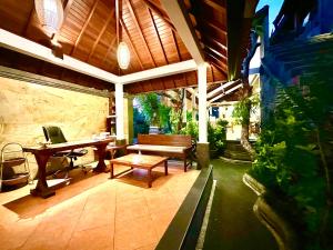 a patio with a bench and a table and a piano at Dupa Ubud in Ubud