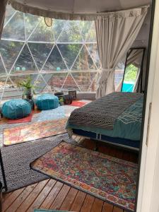 ein Schlafzimmer mit einem Bett und zwei Teppichen auf dem Boden in der Unterkunft Manta Soul Jungle Geodome in Kealakekua