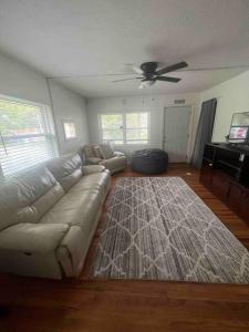 ein Wohnzimmer mit einem Sofa und einem Deckenventilator in der Unterkunft Cozy House on the hill in Tallahassee