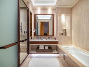 uma casa de banho com uma banheira e um lavatório em The Olympian Hong Kong em Hong Kong