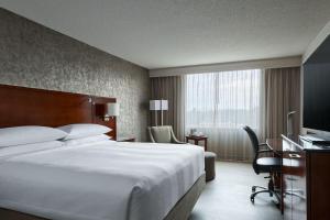 um quarto de hotel com uma cama grande e uma televisão em Hanover Marriott em Whippany