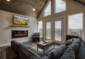 sala de estar con sofá grande y chimenea en Broadview - Mtn Views, River Views, New Build en Kodak