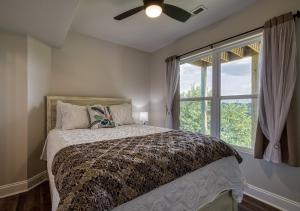 1 dormitorio con 1 cama, ventilador de techo y ventana en Broadview - Mtn Views, River Views, New Build en Kodak