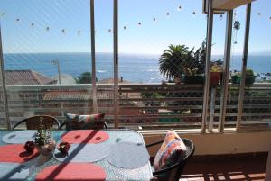 una mesa y sillas en un balcón con vistas al océano en Departamento de Vynka en Algarrobo