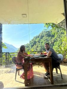 um homem e uma mulher sentados à mesa em Ella Lucky Panoramic em Ella