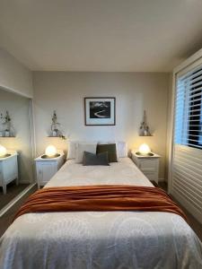 1 dormitorio con 1 cama grande y 2 mesitas de noche en Plantation Boho - 2BR 2BTHRM Northcote Abode, en Melbourne