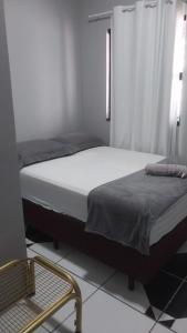 Un dormitorio con 2 camas y una silla. en Ap. 2 quartos próx. Aeroporto en Marabá
