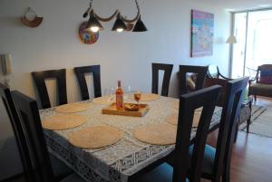 a dining room table with a bottle of wine on it at Departamento de Vynka in Algarrobo