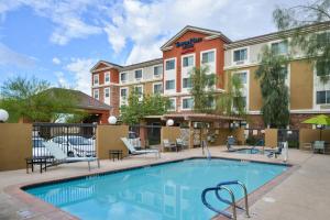 una piscina con sillas y un hotel en TownePlace Suites by Marriott Las Vegas Henderson, en Las Vegas