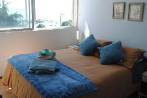 a bedroom with a bed with two bags on it at Departamento de Vynka in Algarrobo