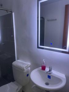 a bathroom with a toilet and a sink and a mirror at Para estrenar agradable apartamento acogedor in Cúcuta