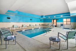 a swimming pool with chairs in a room with blue walls at SpringHill Suites Las Vegas Henderson in Las Vegas