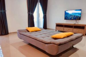 a living room with a couch and a flat screen tv at Binbaba Homestay - Grand Maganda in Batam Center