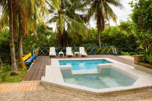 una piscina con 2 sillas y una terraza de madera en Casa Pepper Hill, en San Andrés