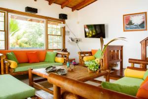 a living room with orange and green couches and a table at Casa Pepper Hill in San Andrés