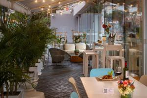 un restaurante con mesas blancas, sillas y plantas en Courtyard by Marriott Lima Miraflores, en Lima