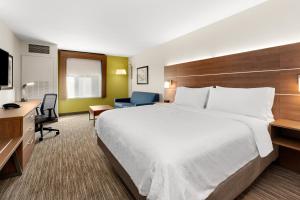Habitación de hotel con cama grande y escritorio. en Holiday Inn Express and Suites Sumner, an IHG Hotel, en Sumner