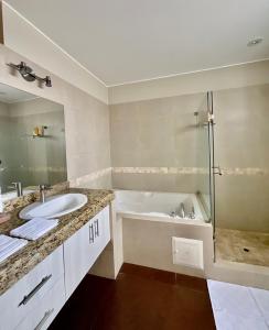 y baño con bañera, lavamanos y ducha. en Modern Apartment with view in San Isidro, en Lima