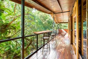 a porch with a table and chairs on it at Wildlife Refuge’s Wood Cabin in Monteverde Costa Rica