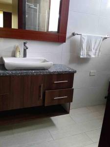 a bathroom with a sink and a mirror at Deluxeguesthouse/vía Spondylus in Manta