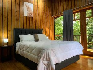 a bedroom with a bed in a wooden wall at Wildlife Refuge’s Wood Cabin in Monteverde Costa Rica