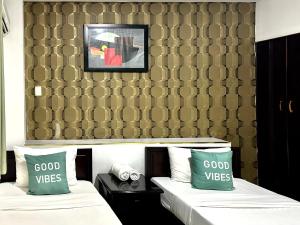 2 camas con almohadas verdes en una habitación de hotel en Anh Duy Hotel - Nguyễn Công Trứ The Bitexco Neighbour, en Ho Chi Minh