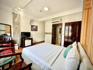 1 dormitorio con 1 cama blanca y TV en Anh Duy Hotel - Nguyễn Công Trứ The Bitexco Neighbour, en Ho Chi Minh