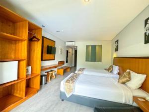 a bedroom with a large bed and a television at Dekuta in Kuta