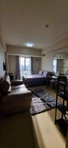 a living room with two couches and a table at 1 Bed 1 Bath Studio in Cagayan de Oro