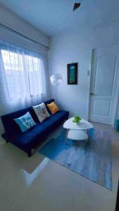 a living room with a blue couch and a table at Urban oasis40 in Talisay