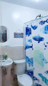 a bathroom with a toilet and a shower curtain at Urban oasis40 in Talisay
