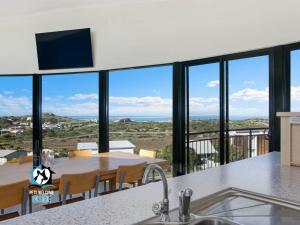 een keuken met een tafel en uitzicht op de oceaan bij Architect Designed Beach House with Sweeping Views in Goolwa South