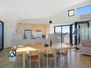 een keuken en eetkamer met een tafel en stoelen bij Architect Designed Beach House with Sweeping Views in Goolwa South