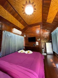 een groot roze bed in een kamer met een plafond bij The Best Garden resort in Sichon