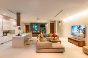 uma ampla sala de estar com um sofá e uma cozinha em Luxurious SeaView 4br Private Pool Villa by Intira Villas em Praia de Rawai