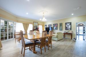 a dining room and living room with a table and chairs at Durham Lodge Bed & Breakfast in Perth